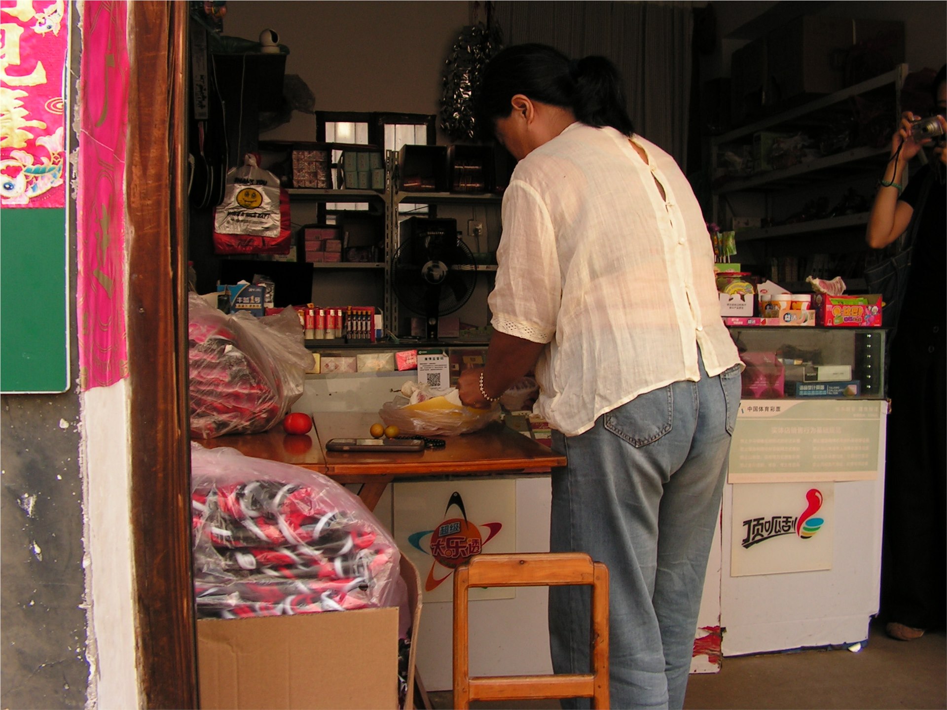 荣华堂内的小店中，一位女士在桌边整理物品